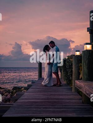 Couple sur la plage de Curaçao pendant le coucher du soleil, hommes et femmes regardant le coucher du soleil sur la plage tropicale de Curaçao pendant les vacances Banque D'Images