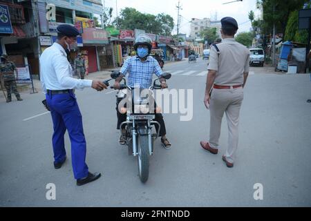 Agartala, État de Tripura, dans le nord-est de l'Inde. 19 mai 2021. Le personnel de police inspecte un motocycliste lors d'un couvre-feu à Agartala, la capitale de l'État indien de Tripura, dans le nord-est de l'Inde, le 19 mai 2021. Le bilan COVID-19 de l'Inde a atteint 25,496,330 mercredi, avec 267,334 nouveaux cas enregistrés au cours des dernières 24 heures, a confirmé le ministère de la Santé. Dans une tentative d'aplatissement de la courbe des cas COVID-19, la plupart des États du pays ont imposé des couvre-feux de nuit et des blocages partiels ou complets. Credit: STR/Xinhua/Alay Live News Banque D'Images