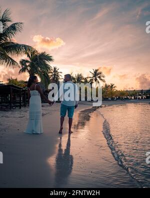 Couple sur la plage de Curaçao pendant le coucher du soleil, hommes et femmes regardant le coucher du soleil sur la plage tropicale de Curaçao pendant les vacances Banque D'Images