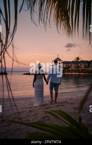 Couple sur la plage de Curaçao pendant le coucher du soleil, hommes et femmes regardant le coucher du soleil sur la plage tropicale de Curaçao pendant les vacances Banque D'Images