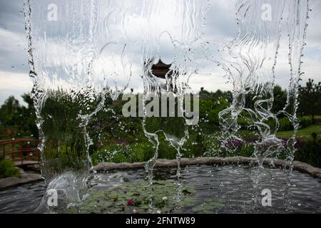 chute d'eau contre le ciel. l'eau qui tombe est gelée dans la photo. photo fraîche des éclaboussures d'eau. Arrêtez-vous au cadre d'une petite chute d'eau dans un parc. Banque D'Images