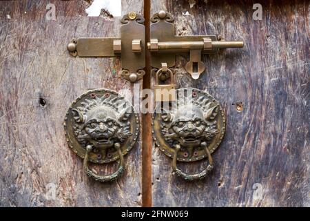 Un knocker à tête de lion sur une porte chinoise traditionnelle Banque D'Images