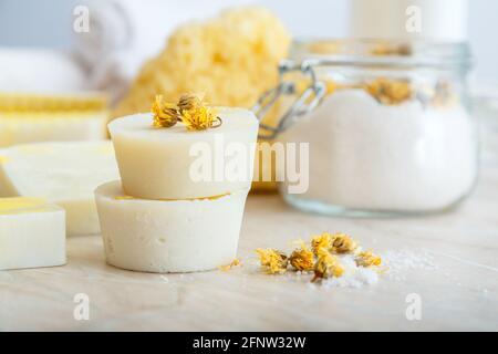 Barre de shampooing solide beaucoup et barres rondes de savon fait main avec des herbes sèches fleurs marigold. Produits de bain spa sel aromatique, débarbouillette naturelle sur marbre Banque D'Images