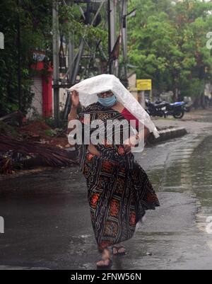 Prayagraj, Uttar Pradesh, Inde. 19 mai 2021. Prayagraj: Une femme porte une feuille de plastique pour être à l'abri de la pluie douche à Prayagraj le mercredi 19 mai 2021. Credit: Prabhat Kumar Verma/ZUMA Wire/Alamy Live News Banque D'Images