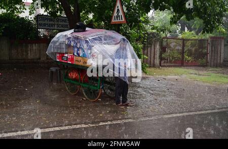 Prayagraj, Uttar Pradesh, Inde. 19 mai 2021. Prayagraj: Un vendeur de côté de route a moufle la feuille de plastique pour être à l'abri de la pluie douche à Prayagraj le mercredi 19 mai 2021. Credit: Prabhat Kumar Verma/ZUMA Wire/Alamy Live News Banque D'Images