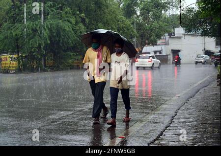 Prayagraj, Uttar Pradesh, Inde. 19 mai 2021. Prayagraj: Commuter partager un parapluie pour être à l'abri de la pluie douche à Prayagraj le mercredi 19 mai 2021. Credit: Prabhat Kumar Verma/ZUMA Wire/Alamy Live News Banque D'Images