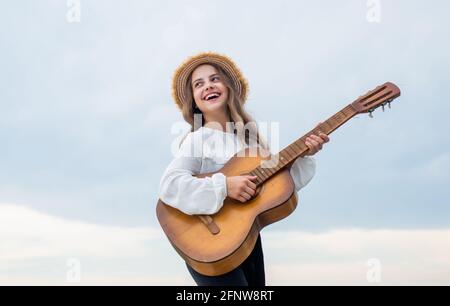 enfant fille élégante jouant de la guitare en plein air, vocal Banque D'Images