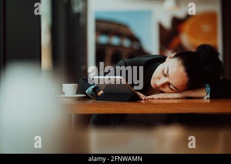 Femme pigiste de style de vie il a repos dormant après un travail dur longtemps dans le café-restaurant Banque D'Images