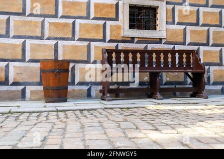 Ancien tonneau en bois brun et banc dans la cour historique pavée de pierre, château de Cesky Krumlov, république tchèque Banque D'Images