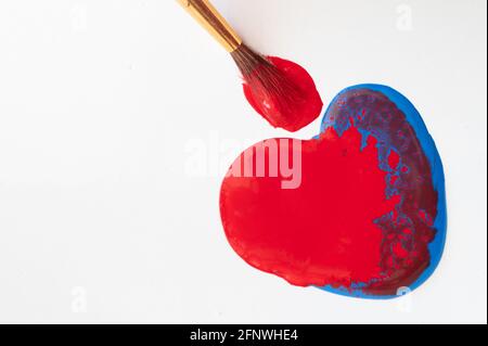 Peinture rouge et bleue en forme de coeur avec pinceau Banque D'Images