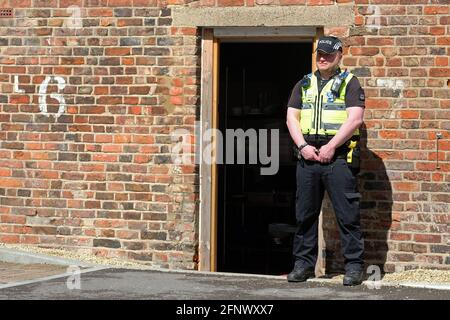 Gloucester, Gloucestershire, Royaume-Uni - mercredi 19 mai 2021 - l'officier de police tient la garde à l'arrière du café Clean plate tandis que la police commence les fouilles dans la recherche de Mary Bastholm qui a disparu en 1968, à peine 15 ans et qui peut avoir été victime d'un tueur en série Fred Ouest. Photo Steven May / Alamy Live News Banque D'Images