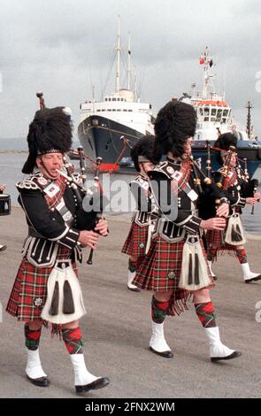 Le Lothian and Borders police Pipe Band se produit alors que le Royal Yacht Britannia arrive au terminal Ocean Liner, à Leith, à Édimbourg, après son dernier voyage où elle devait devenir une attraction touristique. Mardi, 5/5/98. Banque D'Images