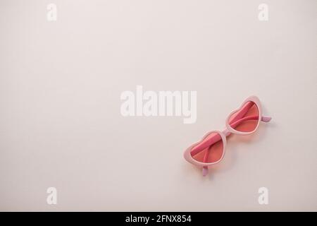 Mise en page. Verres roses sous forme de coeurs sur fond rose clair. Été Banque D'Images