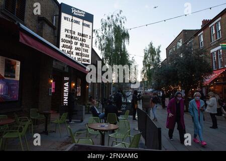 Clapham, Londres, 19 mai 2021 : le public quitte le cinéma Clapham Picturehouse après son premier jour d'ouverture depuis sa fermeture en octobre en raison de la pandémie du coronavirus. De nombreux films ont été retardés de plusieurs mois, voire même plus d'un an. Les activités de loisirs en intérieur n'ont été autorisées que depuis le début de la semaine. Les clients doivent porter un masque facial et les dépistages sont placés à la moitié de leur capacité habituelle. Anna Watson/Alay Live News Banque D'Images