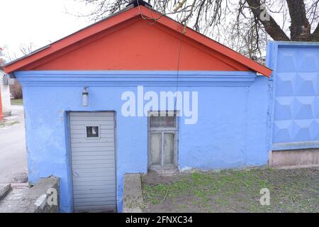 Une vieille petite maison bleue avec un toit rouge dans la ville. Jeu de couleurs. Banque D'Images