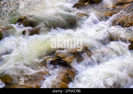 Vue aérienne de la cascade de la rivière avec de l'eau turquoise claire tombant entre des blocs mouillés avec de la mousse blanche épaisse. Banque D'Images