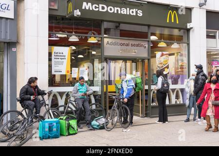 Clients et coursiers le livoo man fait la queue devant le restaurant McDonald's de Cutty Sark, Greenwich, Londres, Angleterre, livraison de nourriture au Royaume-Uni Banque D'Images