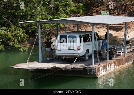 Le ferry de la rivière à une voiture, à manivelle, traverse la rivière Mopan sur la route d'accès aux ruines des pyramides de Xunatunich à San Jose Succotz, Cayo Banque D'Images