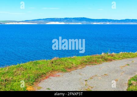 Sentier de randonnée pavé au bord de la falaise à point Reyes Headlands. Vue panoramique sur la baie de Drakes calme bleu eau et le littoral avec spectaculaire falaise de grès blanc Banque D'Images