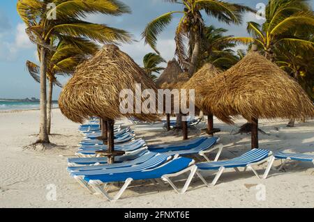 Palapas et chaises longues dans la plage de Xpu-Ha, Caribean mexicain Banque D'Images