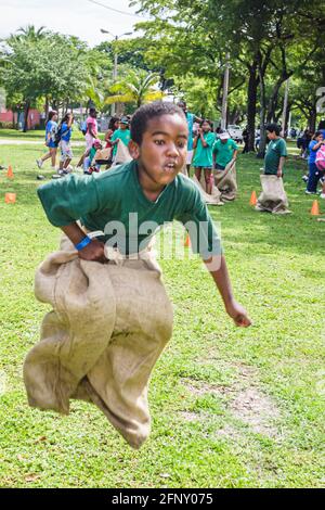 Miami Floride, Hadley Park Dade County Parks Summer Camp Program, course de sacs de pommes de terre Black boy jumping Racing, Banque D'Images