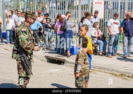 Miami Florida, Orange Bowl après l'ouragan Wilma, distribution gratuite de glace d'eau de nourriture FEMA, soldat de la Garde nationale hispanique garçons hommes file d'attente enfants, Banque D'Images