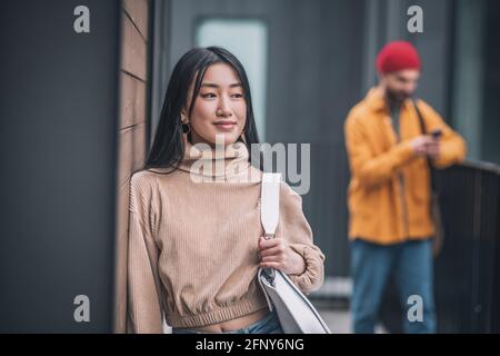 Jeune femme se sentant s'ennuyer pendant que ses garçons parlent sur le téléphone Banque D'Images