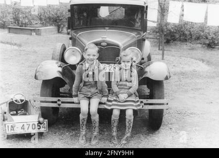 Personnes, enfants, groupe / frères et sœurs - mixte, garçon et fille assis sur le pare-chocs d'une voiture, Berlin, DROITS-SUPPLÉMENTAIRES-AUTORISATION-INFO-NON-DISPONIBLE Banque D'Images