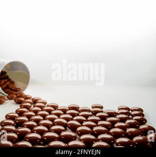 Anti stress naturel ou des comprimés de sommeil pour aider à se détendre en se déversant de la bouteille sur fond blanc, médecine alternative à base de plantes. Banque D'Images