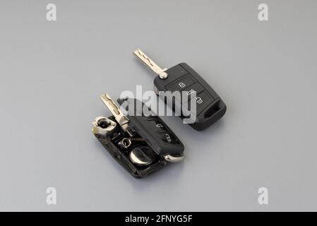 Porte-clés de voiture cassé ou endommagé et nouvelle clé de véhicule à distance sur fond gris. Réparation d'une télécommande cassée ou endommagée de tout service de voiture. Banque D'Images