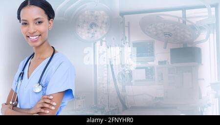 Portrait d'une travailleuse de santé afro-américaine souriant contre l'hôpital en arrière-plan Banque D'Images
