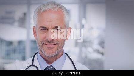 Portrait d'un médecin de sexe masculin de race blanche contre un hôpital en arrière-plan Banque D'Images