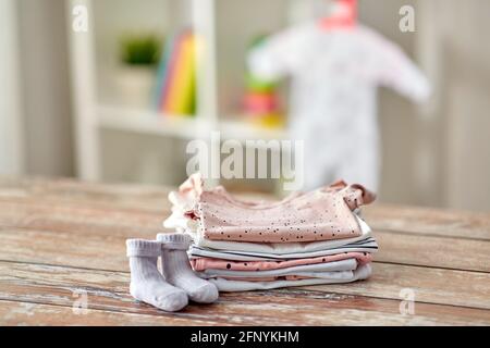 des vêtements de bébé sur une table en bois à la maison Banque D'Images