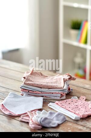 des vêtements de bébé sur une table en bois à la maison Banque D'Images