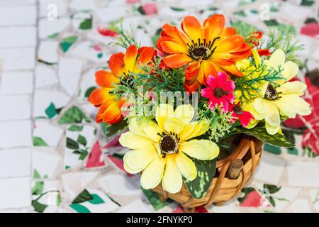 Fleurs artificielles dans un vase en bois sur fond blanc Banque D'Images