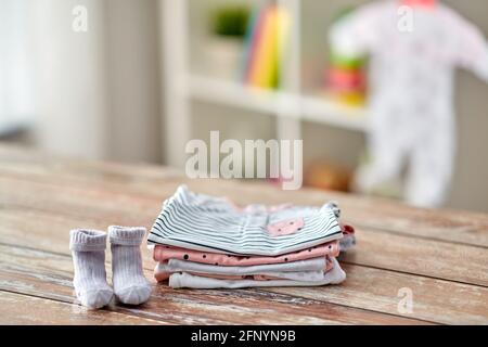 des vêtements de bébé sur une table en bois à la maison Banque D'Images