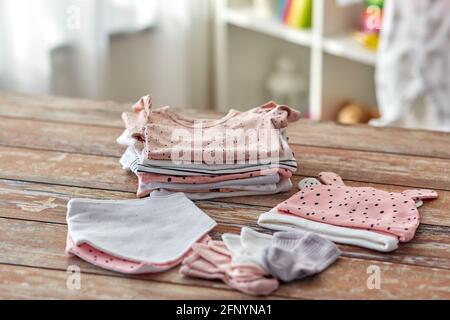 des vêtements de bébé sur une table en bois à la maison Banque D'Images