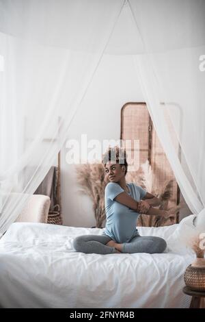 Femme qui fait de l'exercice le matin assis sur le lit Banque D'Images