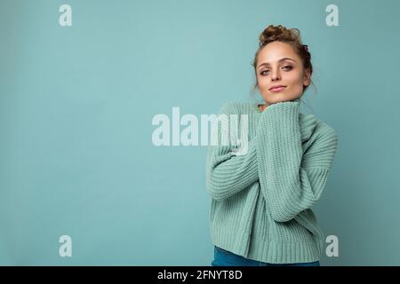 Portrait de jeune heureux positif satisfait mignon confortable attrayant beau femme blonde avec des émotions sincères portant décontracté pull-over bleu isolé activé Banque D'Images