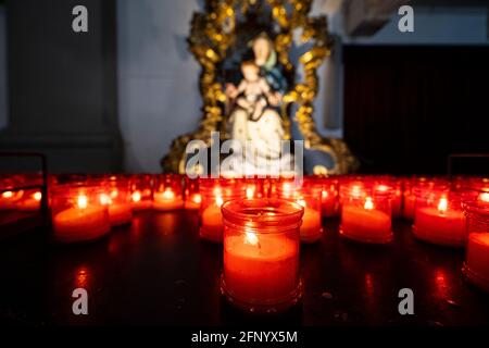 Palmanova, Italie. 18 mai 2021. Quelques bougies allumées devant la statue de la Vierge dans une église Banque D'Images