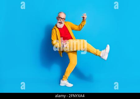 Photo pleine grandeur d'un grand-père joyeux et plein de funky jouer de la guitare invisible isolée sur fond bleu Banque D'Images