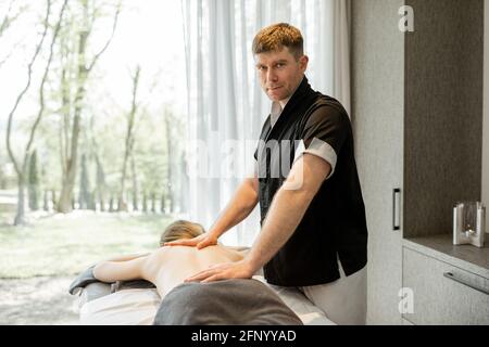 Un portrait d'un masseur masculin faisant un massage à une cliente féminine dans un complexe de spa. Bien-être et loisirs. Passez un temps utile pour les soins de santé. Banque D'Images