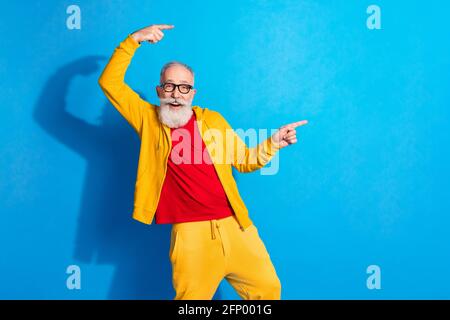 Photo de funky drôle gai souriant excité homme annonce produit pointe doigts espace de copie isolé sur fond bleu Banque D'Images