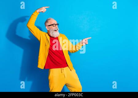 Photo de funky drôle sourire positif homme dans des verres point promotion de l'espace de copie des doigts isolée sur fond bleu Banque D'Images