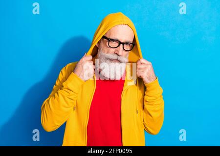 Photo de beau hipster attrayant grand-père en lunettes porter jaune combinaison isolée sur fond bleu Banque D'Images