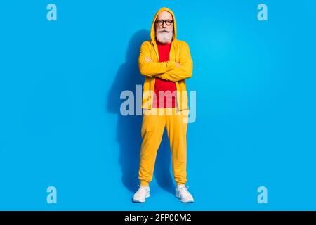 Photo pleine grandeur d'un élégant homme mûr et confiant vêtement de survêtement mains pliées isolées sur fond bleu Banque D'Images