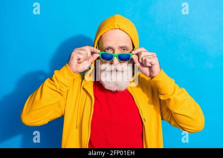 Photo de beau cool confiant homme d'affaires hippster dans la véranda de lunettes de soleil porter un survêtement isolé sur fond bleu Banque D'Images