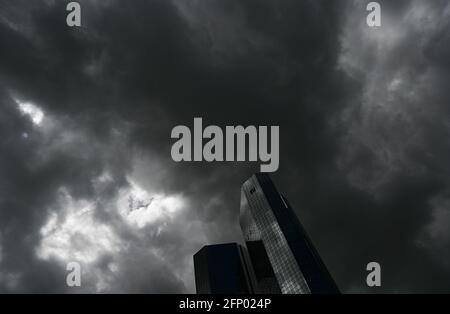 19 mai 2021, Hessen, Francfort-sur-le-main : des nuages sombres passent au-dessus du siège de la Deutsche Bank, tandis que le ciel nuageux se reflète dans la façade. Photo: Arne Dedert/dpa Banque D'Images