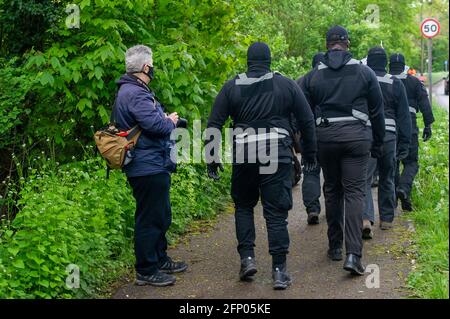 Aylesbury, Buckinghamshire, Royaume-Uni. 19 mai 2021. Les résidents locaux et les militants de Stop HS2 protestaient pacifiquement aujourd'hui à Aylesbury contre le train High Speed 2 qui provoque une énorme destruction dans tout le Buckinghamshire. Des hommes vêtus de Balaclava travaillant pour HS2 en uniforme noir, l'équipe d'intervention en cas d'incident, ont demandé aux manifestants de se déplacer, mais comme la manifestation était légale et sur un trottoir public, les manifestants avaient tout le droit de rester et de poursuivre leur manifestation. Crédit : Maureen McLean/Alay Banque D'Images