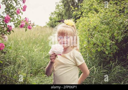 jolie petite fille tenant la fleur dans la prairie Banque D'Images